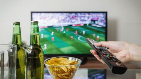 Televizyonda futbol maçı izleyen kişi